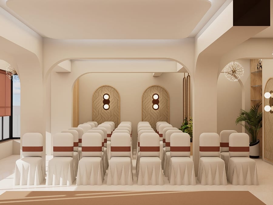 Open banquet area with a raised stage end and patterned flooring | Shirgaonkar Beach Resort