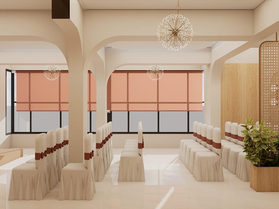 Coral banquet hall with draped chairs set in rows between arched pillars | Shirgaonkar Beach Resort