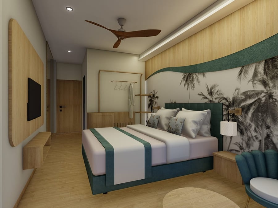 Deluxe Room with a wall-mounted television on a wood panel and a fluted teal armchair | Shirgaonkar Beach Resort
