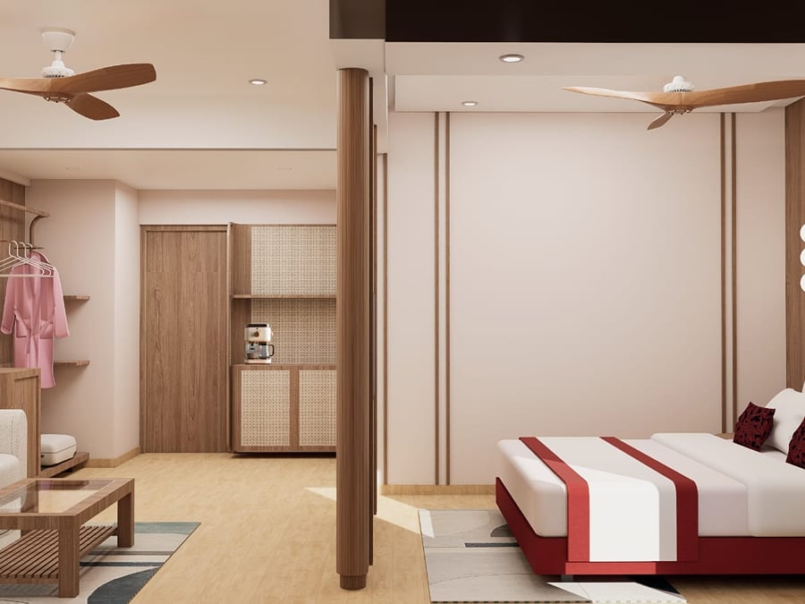 Suite bed in red upholstery with white linen, set beyond a wooden partition column | Shirgaonkar Beach Resort