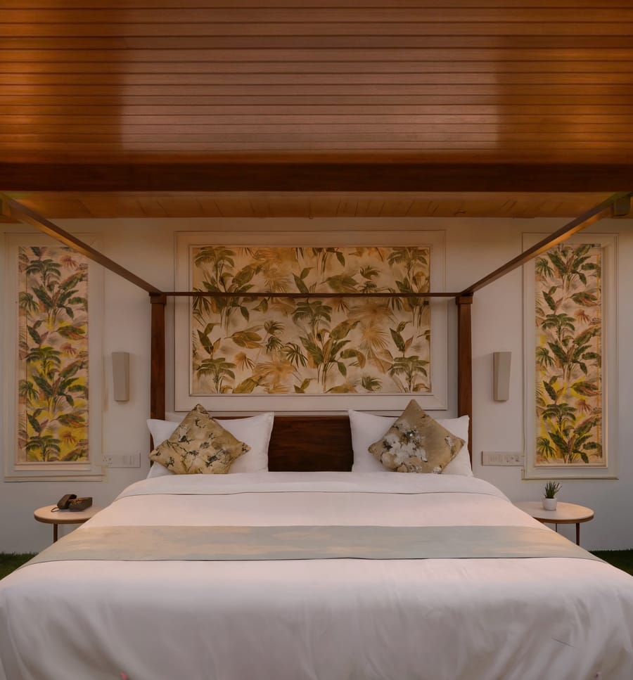 King-size canopy bed with botanical wallpaper headboard inside a Luxe Cottage room at Nazaara Nature Retreat, Dalhousie.