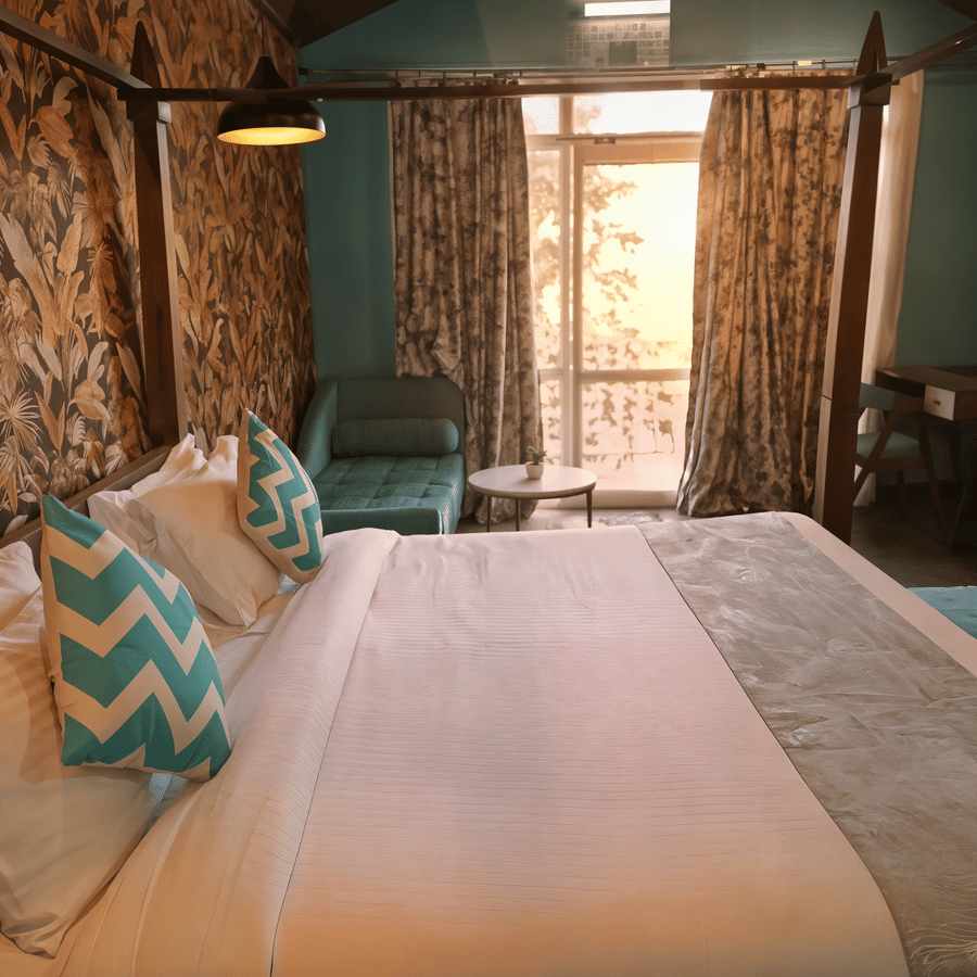 Premium Cottage bedroom at Nazaara Nature Retreat, Dalhousie, with the four-poster bed and botanical wallpaper in view.