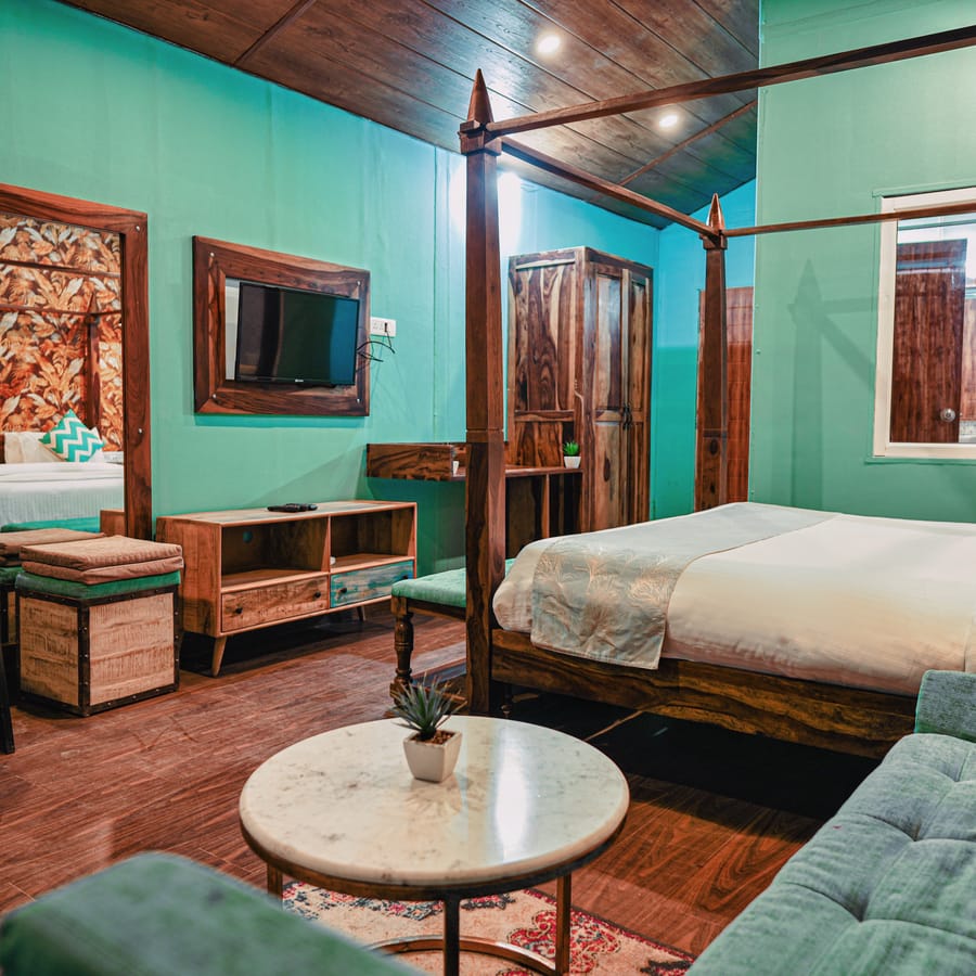 Four-poster bed with botanical-print headboard panels in a guest room at Nazaara Nature Retreat, Dalhousie