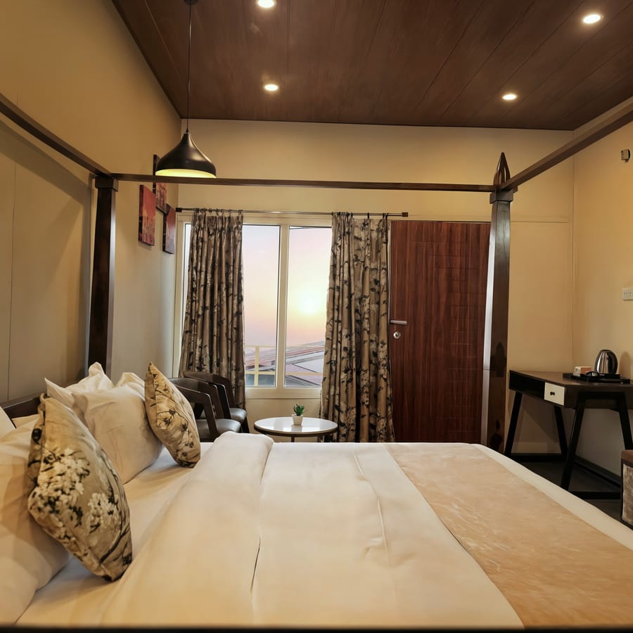 Superior Room at Nazaara Nature Retreat, a neatly made bed and wooden furnishings beside a private balcony with hill views