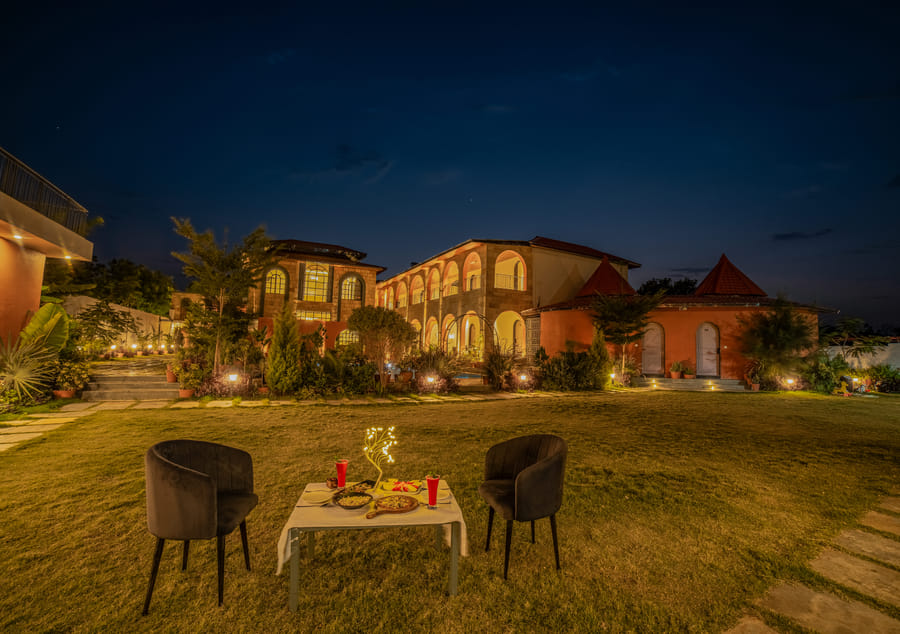A candlelit table set for dinner at Nazaara Fine Dine, Nazaara Hills Retreat, Udaipur, ready for guests.