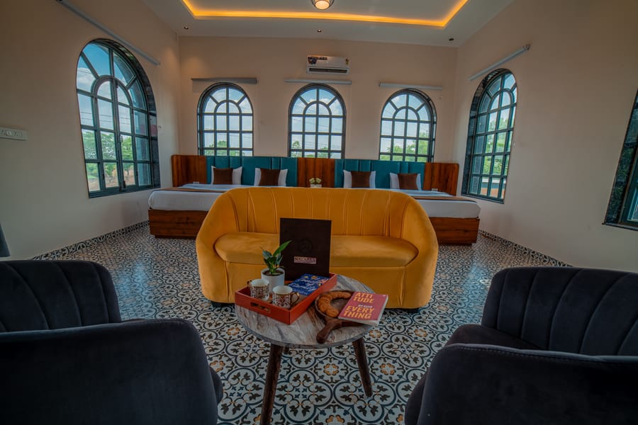 Twin beds and sofa seating in the Nazaara Family Suite at Nazaara Hills Retreat, Udaipur