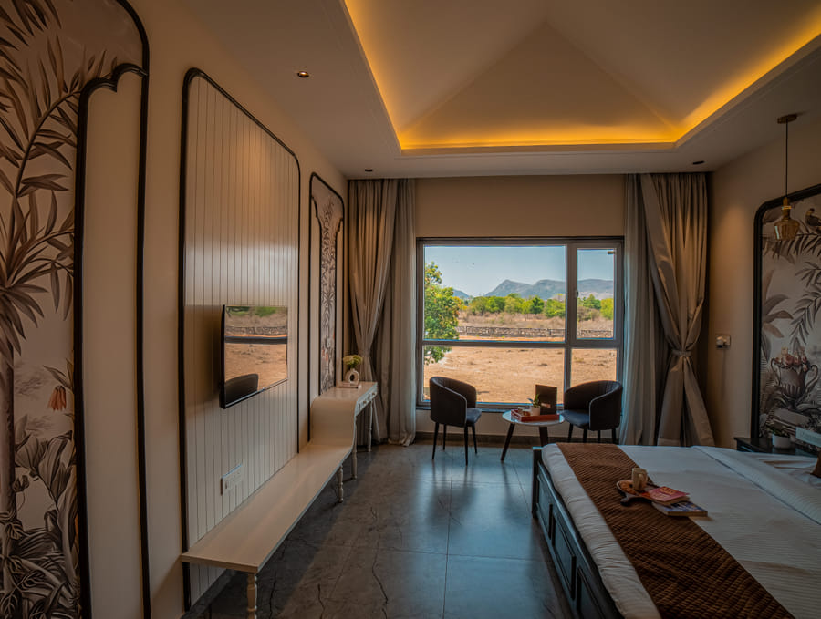 The Superior Room's king-size bed and seating area at Nazaara Hills Retreat, Udaipur