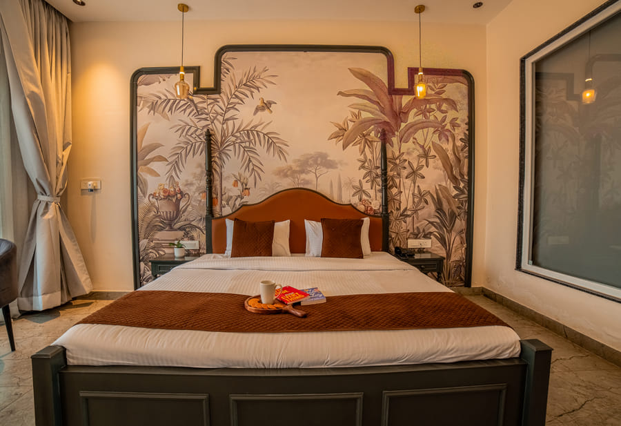 Close-up of the king-size bed with warm linens in the Superior Room at Nazaara Hills Retreat, Udaipur