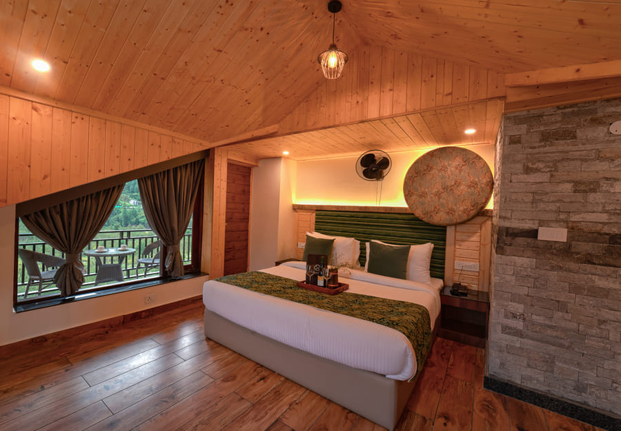 Bed beside the private balcony of the Nazaara Luxe room at Nazaara Luxe Retreat, Manali, mountain view through the window