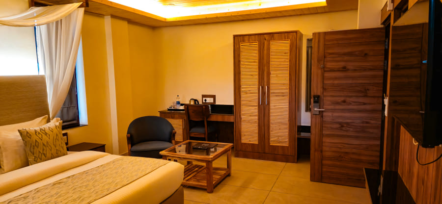 Wardrobe and work desk positioned along one wall of the Premium Room at Nazaara Luxe Retreat, Manali