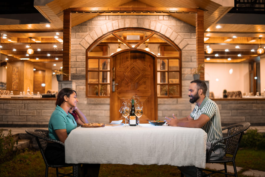 Couple dining outdoors at the restro-cafe of Nazaara Luxe Retreat, Manali