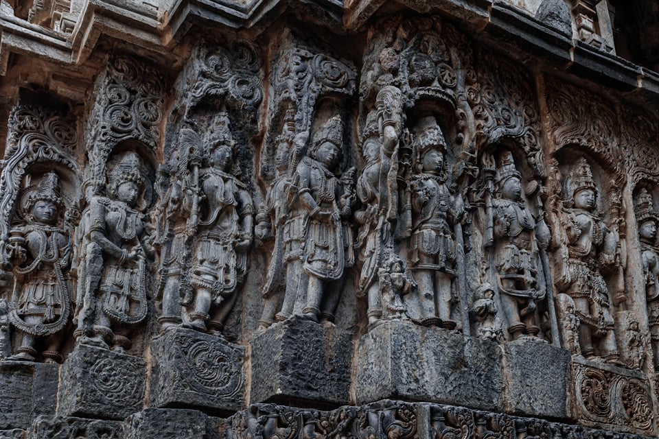 Rows of intricately carved Hoysala sculptures on a temple wall at Halebeedu