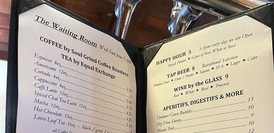An open menu with text on both pages, held in a person's hands.