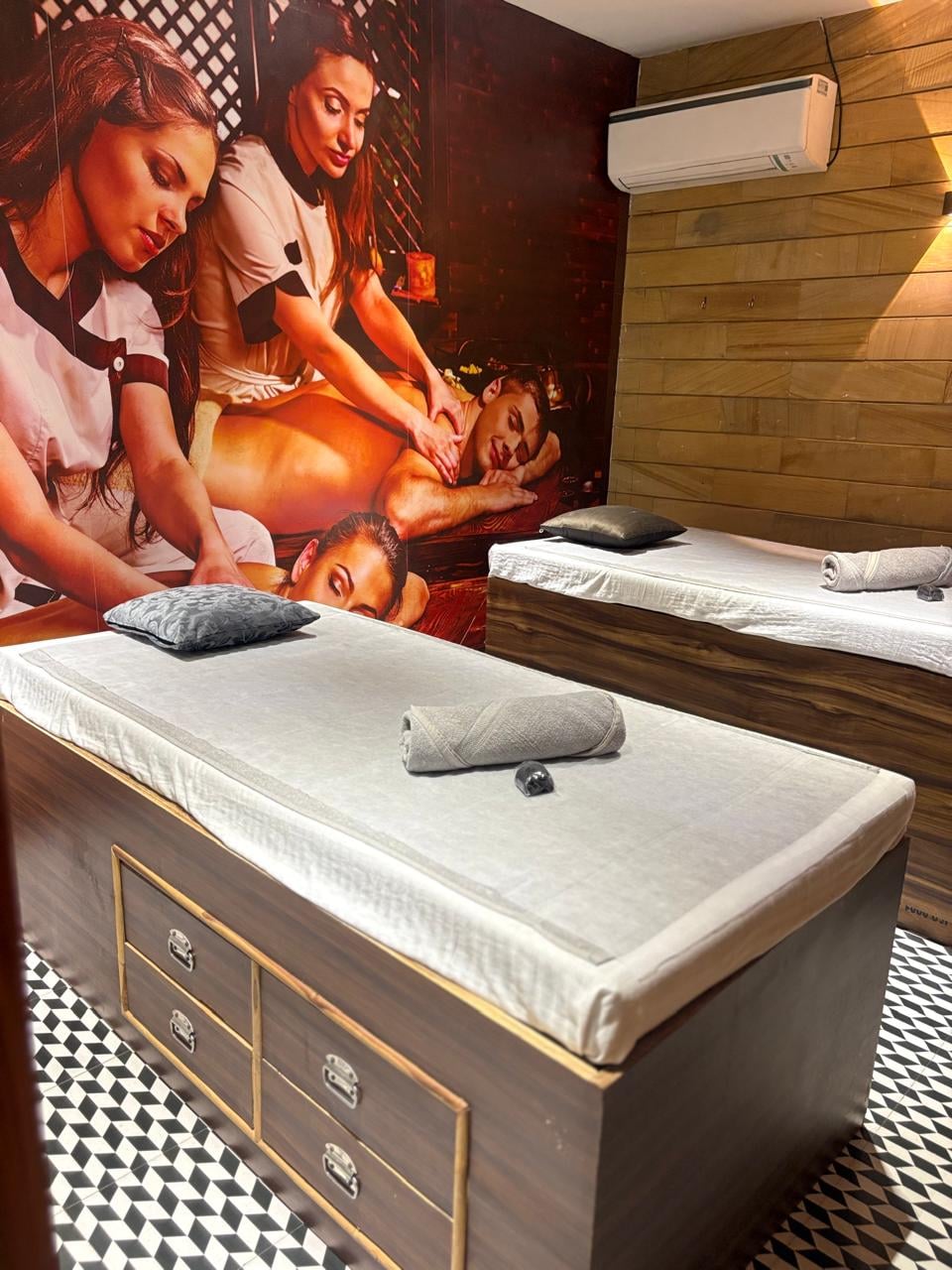SKYN Spa treatment bed with fresh linen and a rolled towel beside a massage mural