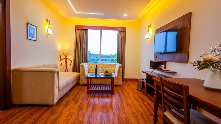 Seating area of the suite with sofas and dining table at Vagator Downtown, Goa 