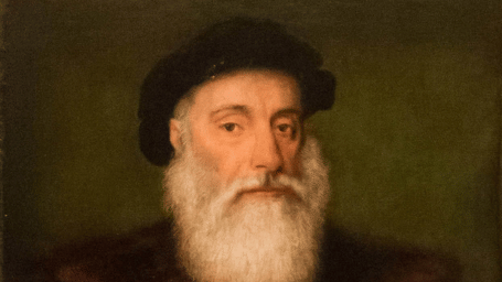 Oil painting portrait of Vasco da Gama, a bearded man in dark clothing with a white cross and fur trim, holding a document.