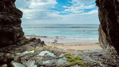 Natural cave located near a clear blue sea