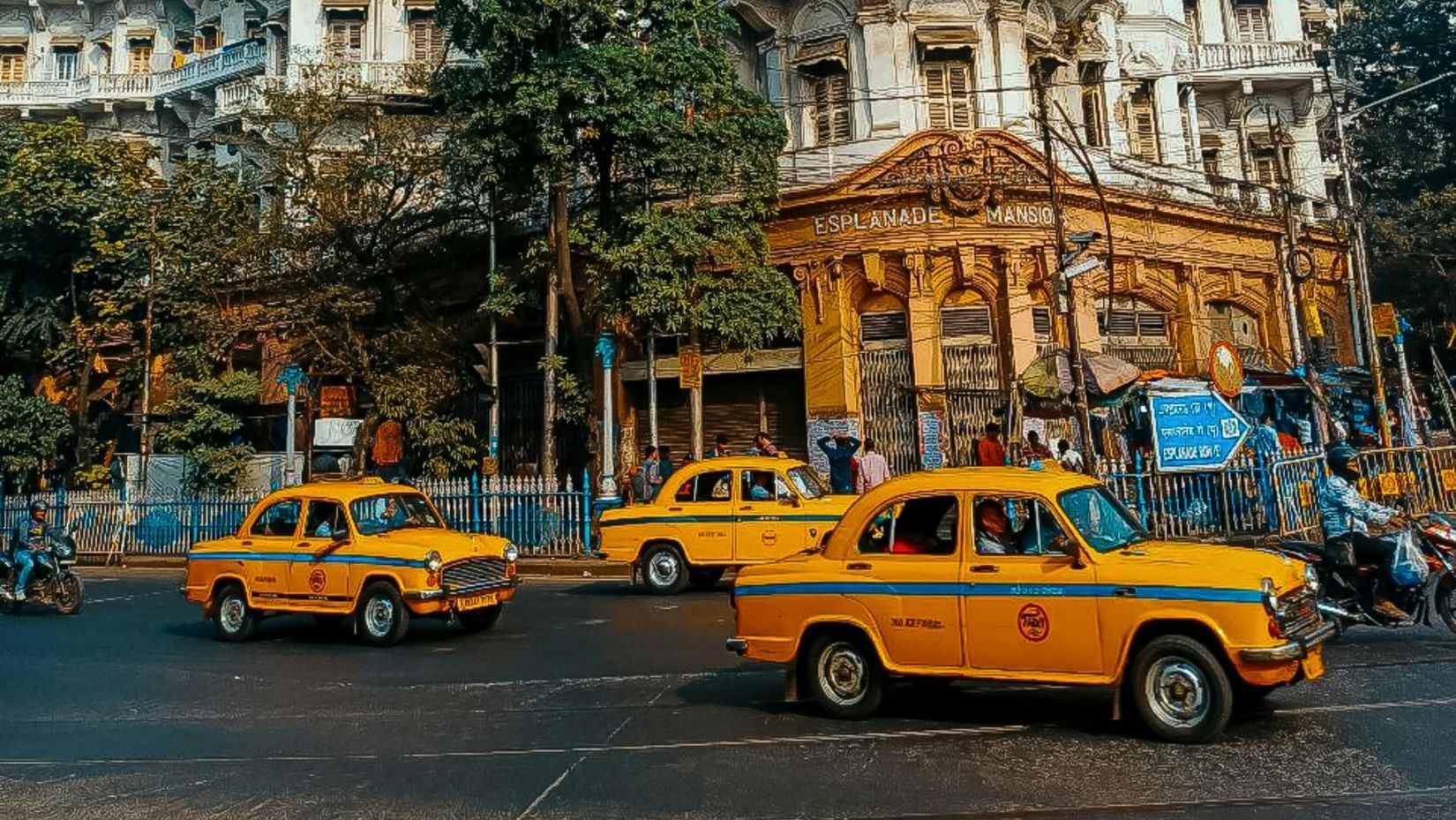 An image of the streets of Kolkata with yellow taxis and a building in the background