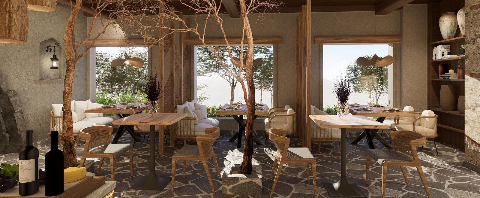 Side view of the restaurant at The Evren, Vagator, with arranged tables, chairs, and windows overlooking greenery.