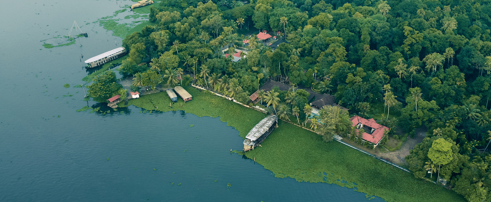 An aerial shot showcasing the Vembanad Lake and the resort surrounded by lush greenery - BluSalzz Villas - Muhamma Resort, Alleppey