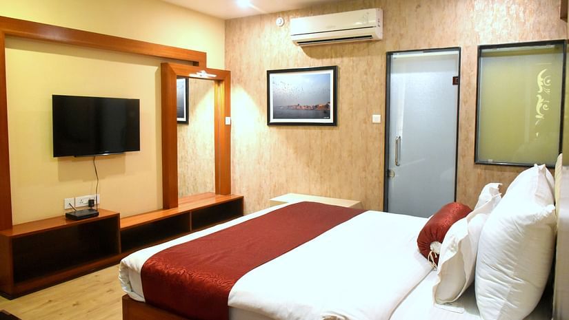 A sideview of bed in Presidential Suite with TV and A/C | Hotel City Inn, Varanasi