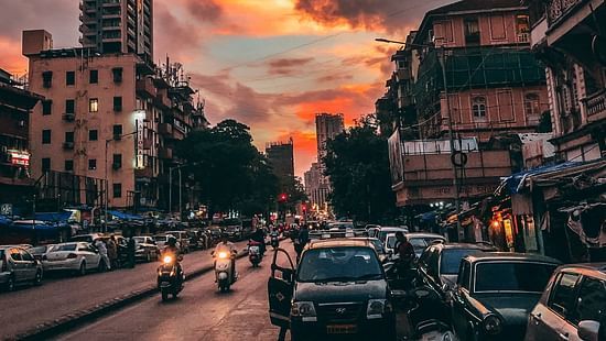 an image of a street in the evening featuring vehicles and building