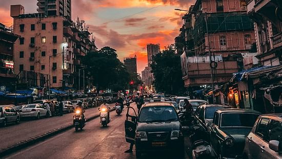 an image of a street in the evening featuring vehicles and building