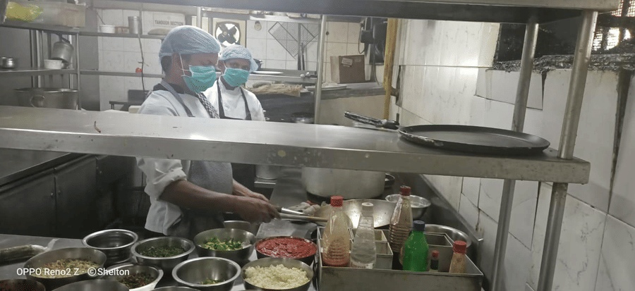 a close up shot of chefs inside a kitchen working on a dish - VITS Hotels & Resorts