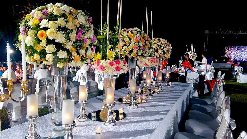An overview of a table with decorations, vases and flowers during a wedding - wedding at beach resort in South Goa - Caravela Beach Resort, Goa.