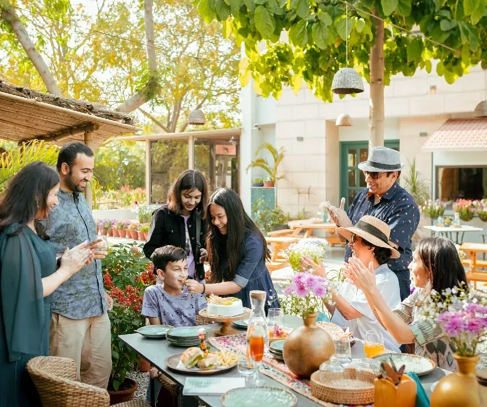 Group dining outdoors under trees at Karma Chalets.