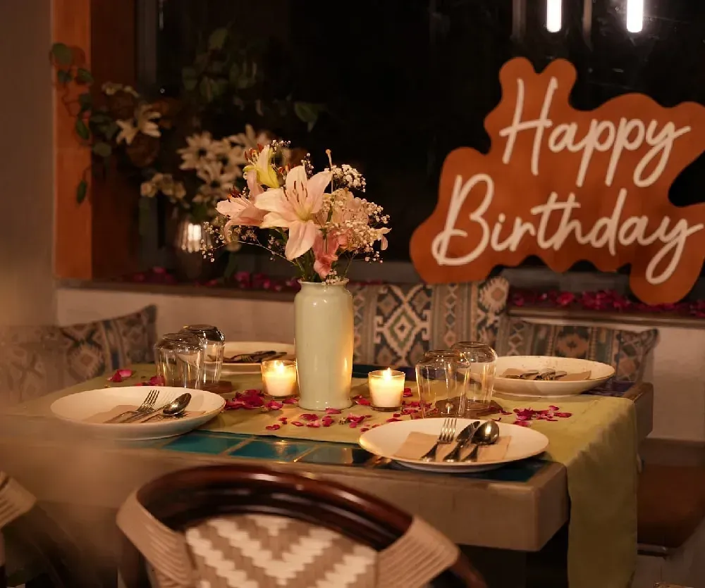 Table setup for a birthday celebration with flowers and lights at Karma Chalets.