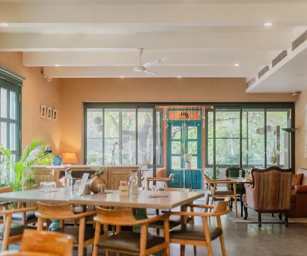 Dining area with wooden tables and chairs inside Karma Chalets.