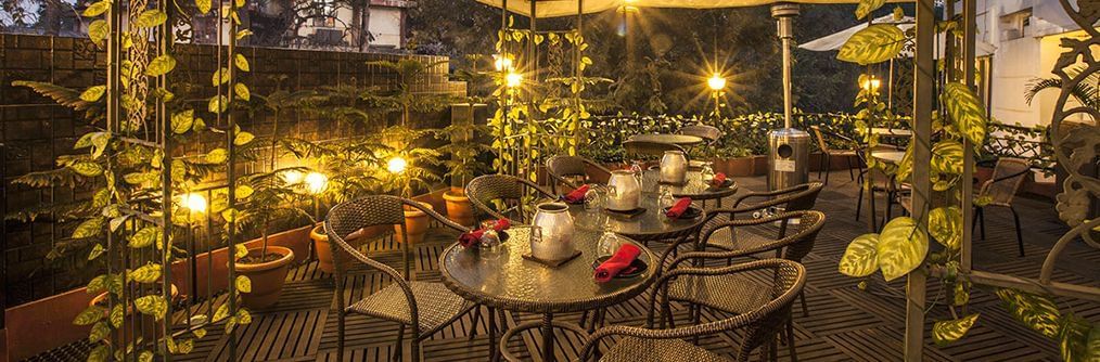 A panoramic view of the beautifully lit courtyard dining area at night, located at the Polo Hotel Shillong.