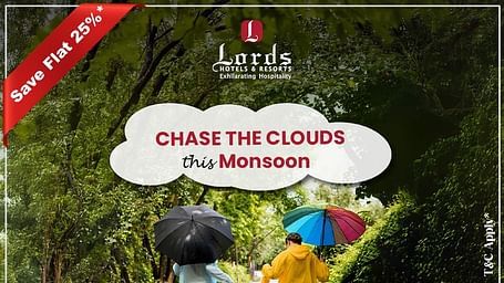 People with colorful umbrellas walk on a green forest path. Lords Hotels monsoon offer, save 25%, book by Sept 25, stay till Sept 30.