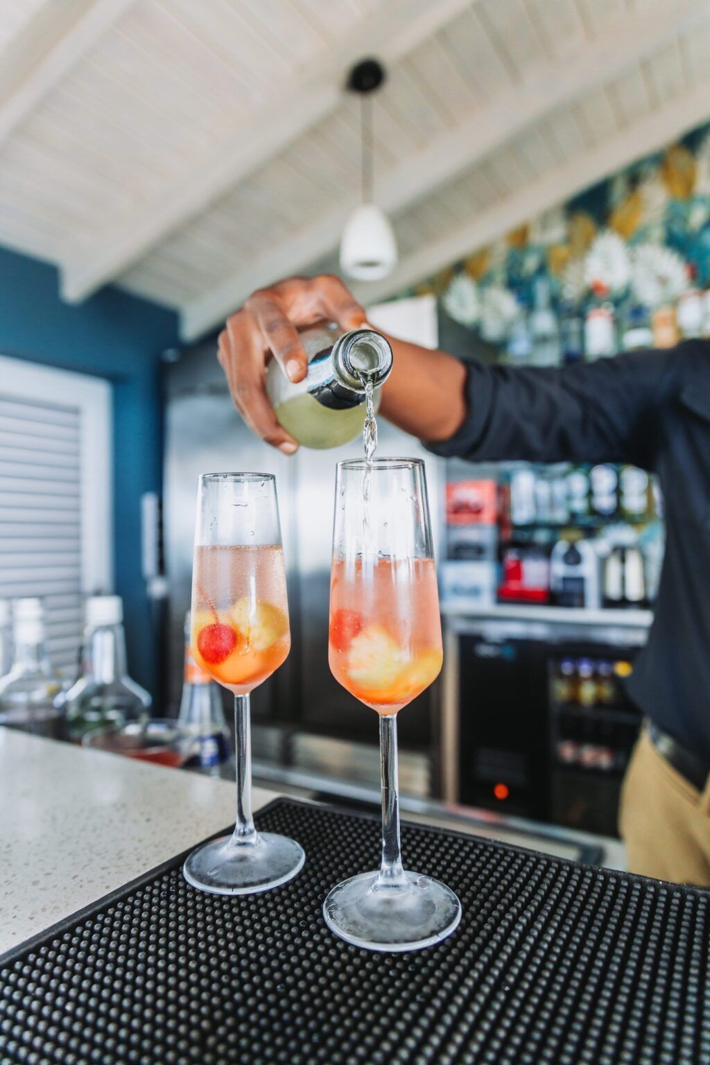A bartendar making drinks on the counter table.
