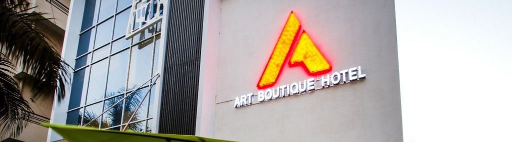 Exterior view of  Art Boutique Hotel, Hyderabad, with a sitting area outisde cover with an umbrella