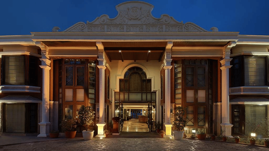 Pillars framing the grand illuminated entrance of a building at dusk at Ramada by Wyndham Mussoorie Mall Road.