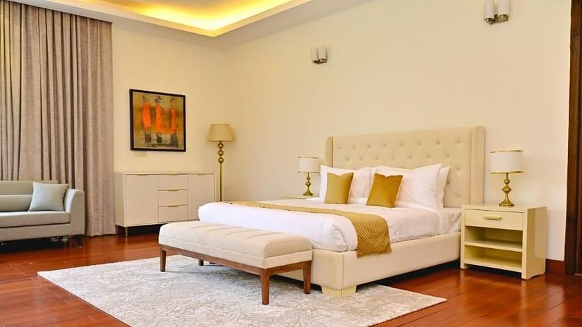 Shot of a pastel coloured themed room with a kind size bed, yellow pillows