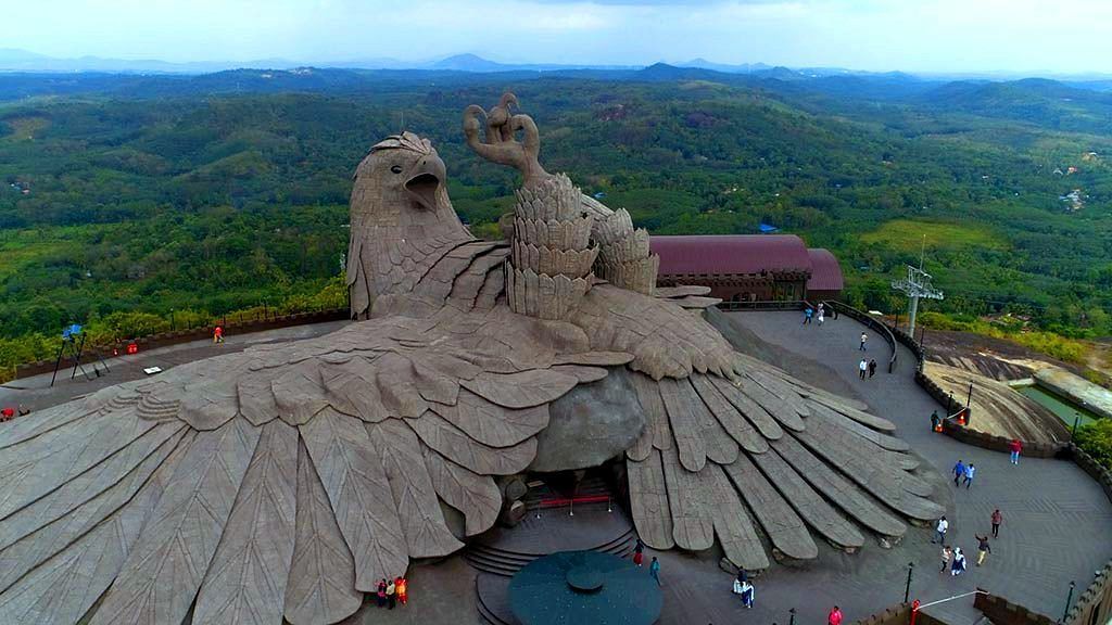  Eagle lying on the ground, carved into a massive rock, so large that a person barely reaches a quarter of its nail's size