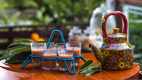 Traditional Indian tea set with a decorative kettle and glasses on a tray.