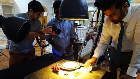 Photographer and food stylist working on a dish for a photoshoot.