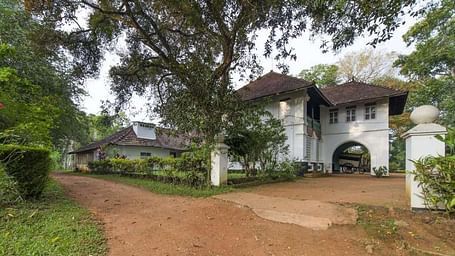 A facade image of serenity at Kanam Estate surrounded by green trees