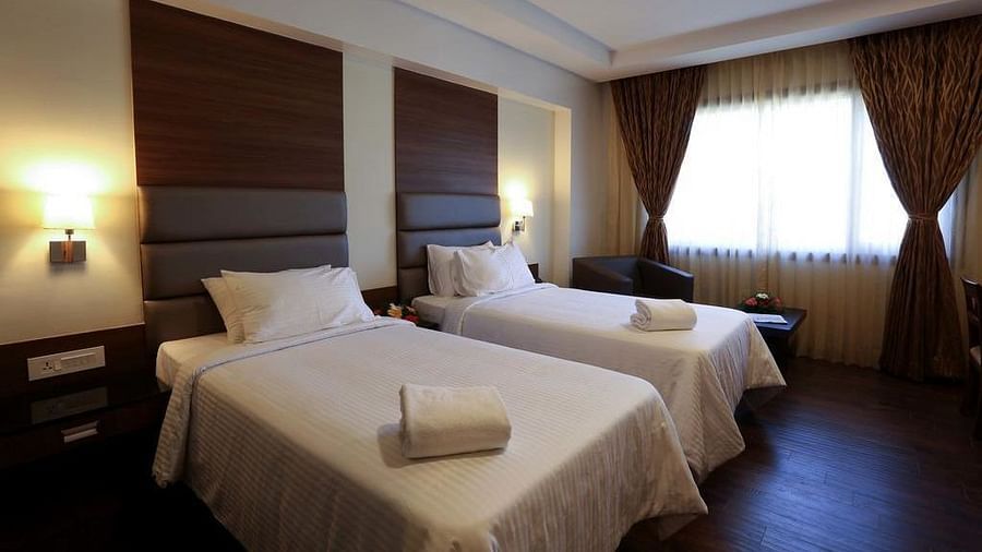 Room wtih twin beds and lamps on both sides on the bed at Fressotel Seetharam, Coimbatore