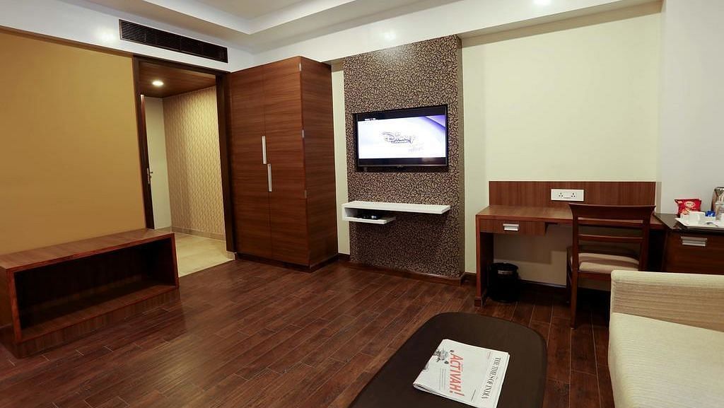 Sapcious room with wooden flooring, wooden wardrobe and study area at Fressotel Seetharam, Coimbatore