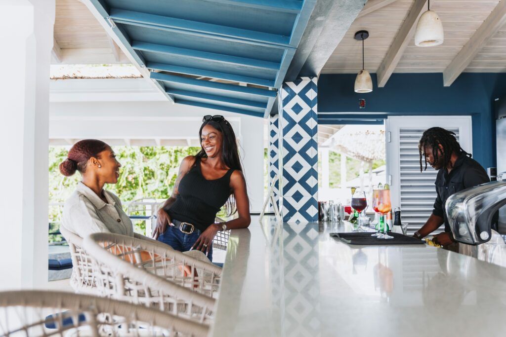 Two people looking at each other in a breezy, blue-and-white open-air kitchen at Tamarind Hills.