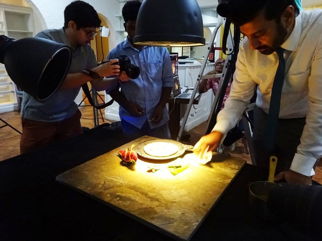 Photographer and food stylist working on a dish for a photoshoot.