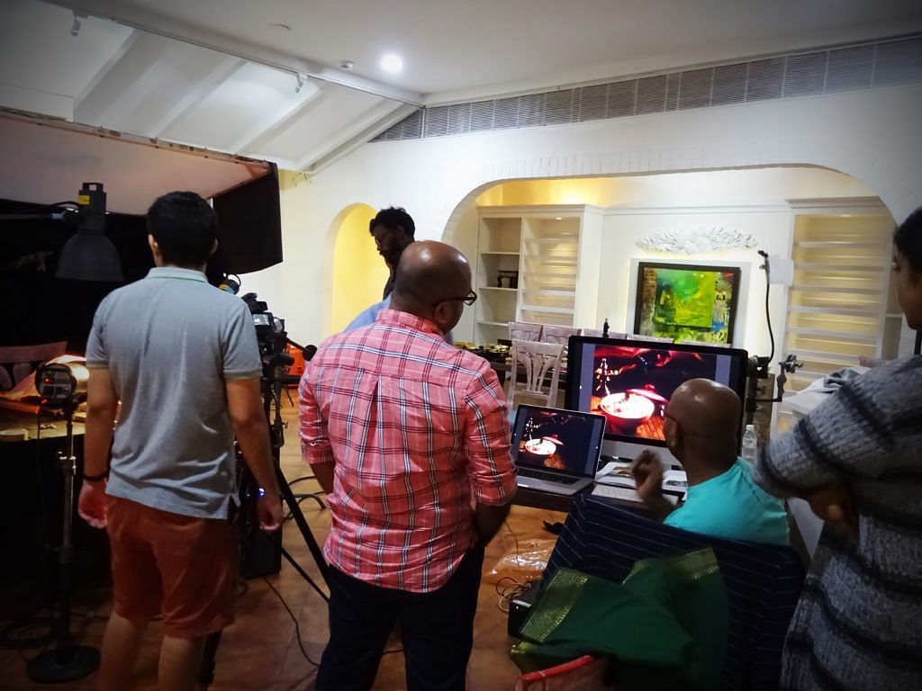 Group of people setting up a food photography scene with equipment.