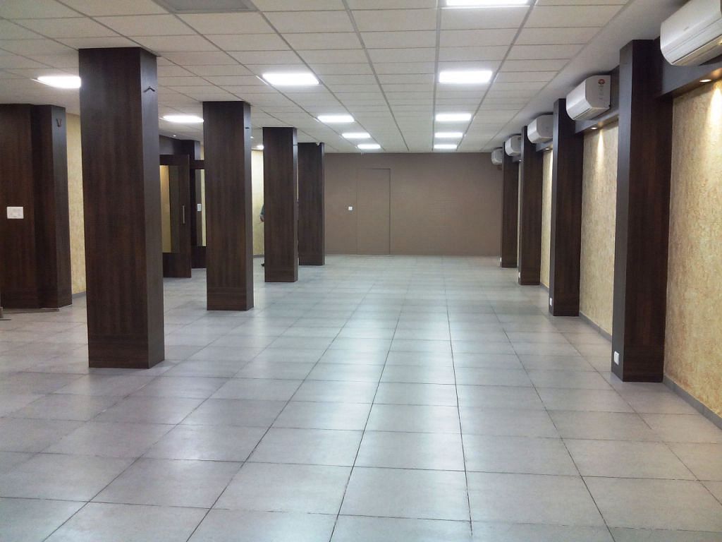 Spacious corridor or hall with tiled floor and wooden columns