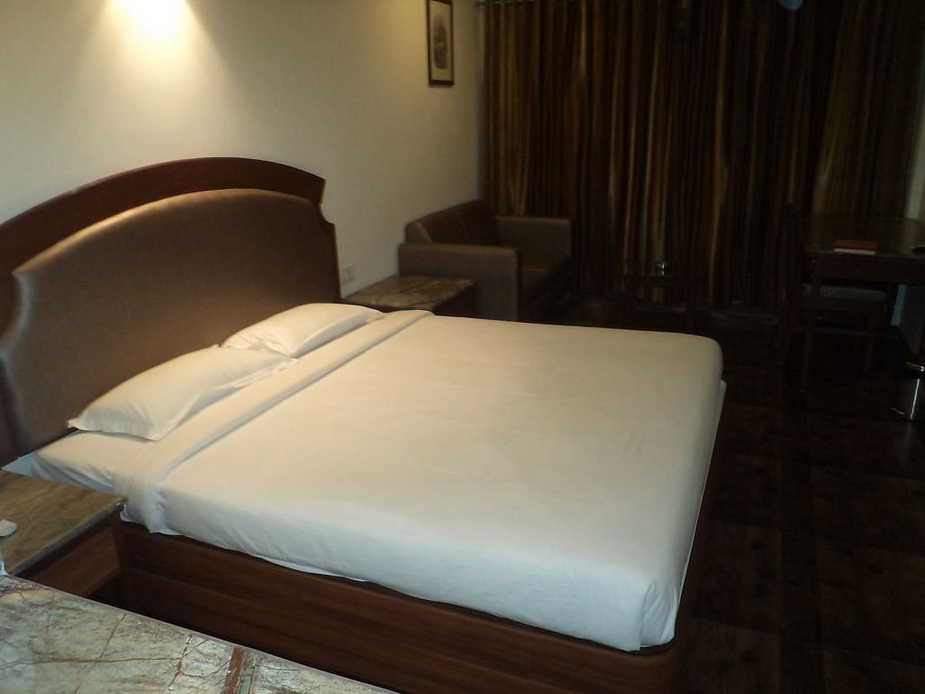 Cozy hotel room with a double bed and dark curtains