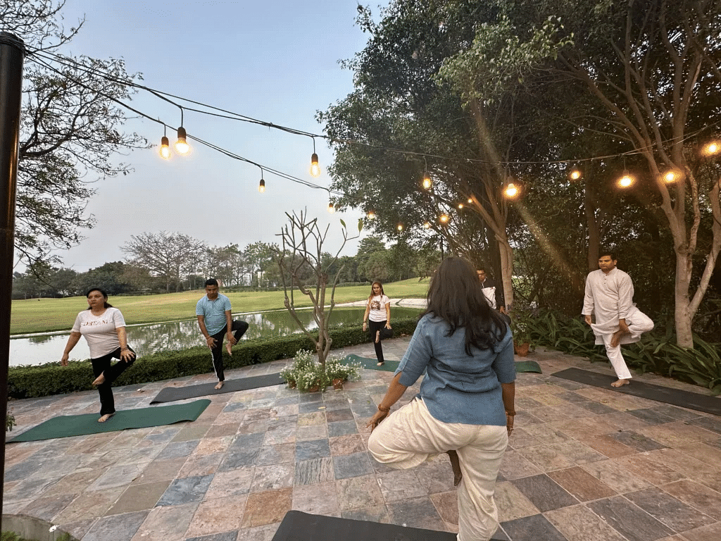 People doing outdoor yoga under string lights at Karma Chalets.